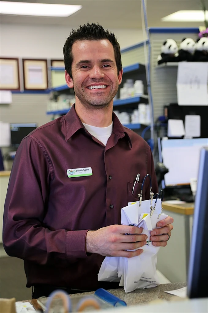 Dan Lindstrom, Cascade Pharmacy staff member, smiling at the counter